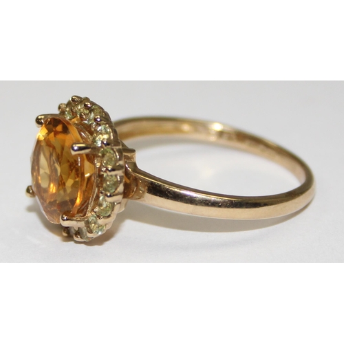 2077 - A 9ct gold citrine dress ring, a large facet cut round central stone surrounded by small white stone... 