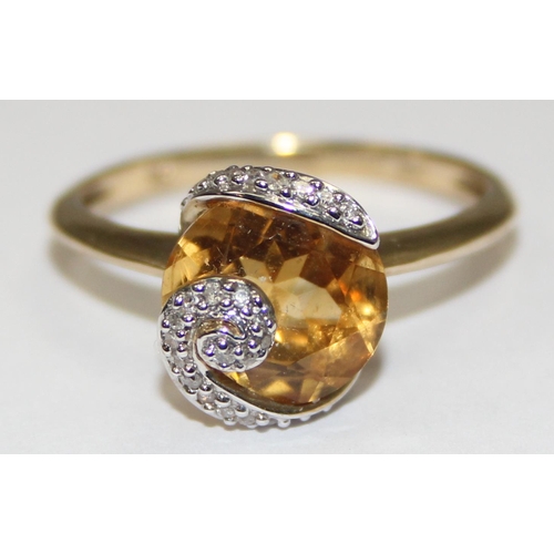 2078 - A retro style 9ct gold citrine dress ring, a large facet cut round central stone surrounded by a rib... 