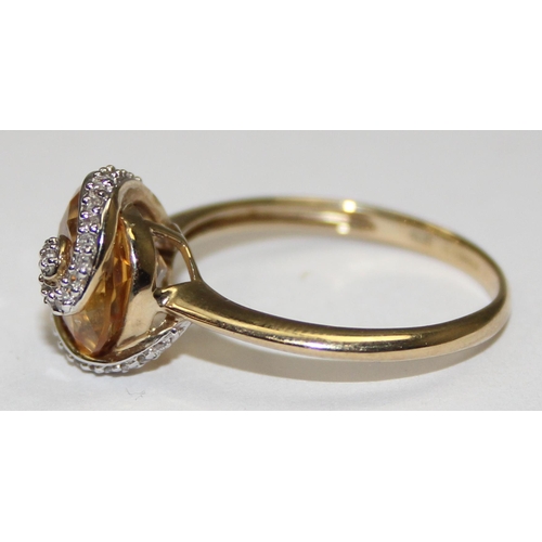 2078 - A retro style 9ct gold citrine dress ring, a large facet cut round central stone surrounded by a rib... 