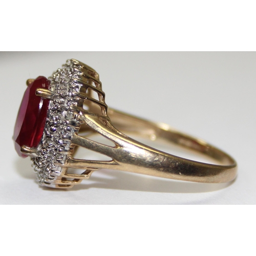 2083 - A 9ct gold deep red pink stone cocktail ring surrounded by small diamonds, full English hallmarks, a... 