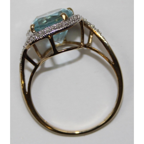 2085 - A 9ct gold retro style light blue stone cocktail ring surrounded by small diamonds in a crossover se... 