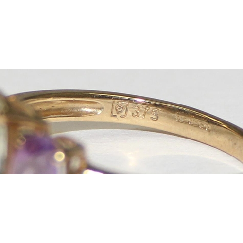 2111 - A 9ct gold trilogy ring, a white stone flanked by 2 light purple stones, full English hallmarks, app... 