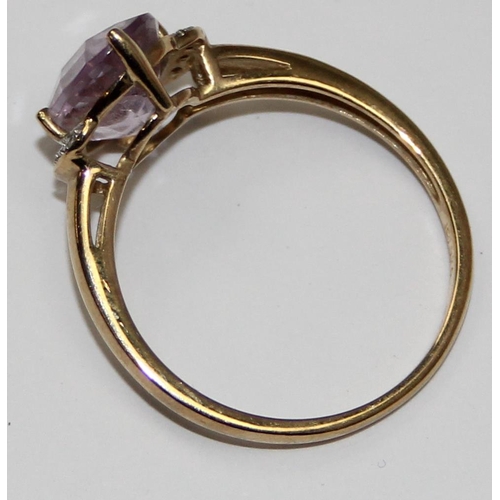 2113 - A 9ct gold ring comprising of a light purple stone flanked by small diamonds, full English hallmarks... 