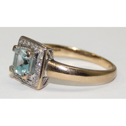 2114 - A 9ct gold Art Deco style ring comprising of a light blue asscher cut stone flanked by small diamond... 