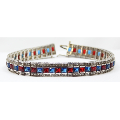 2273 - An Art Deco style 925 silver tennis bracelet, an alternating row of red and blue stones flanked on e... 