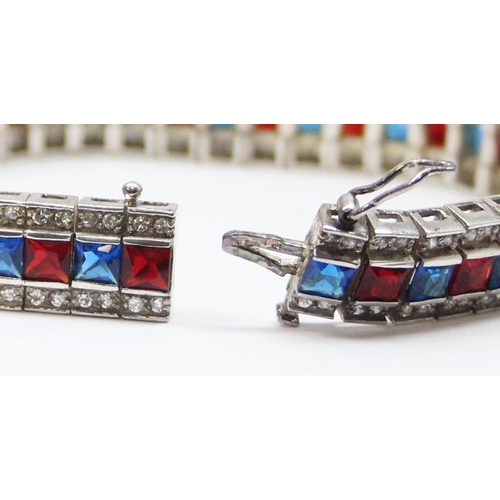 2273 - An Art Deco style 925 silver tennis bracelet, an alternating row of red and blue stones flanked on e... 