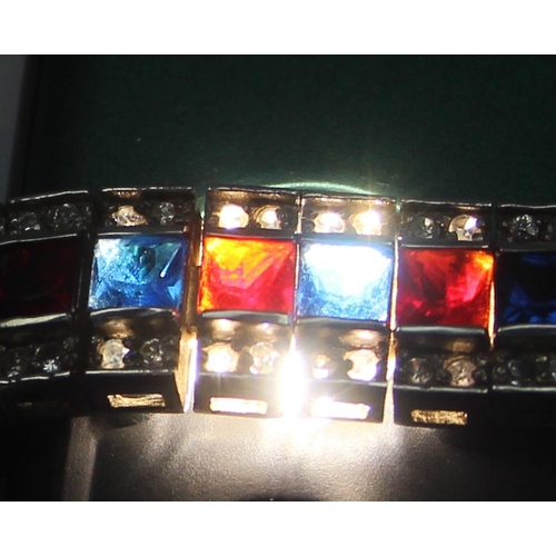 2273 - An Art Deco style 925 silver tennis bracelet, an alternating row of red and blue stones flanked on e... 