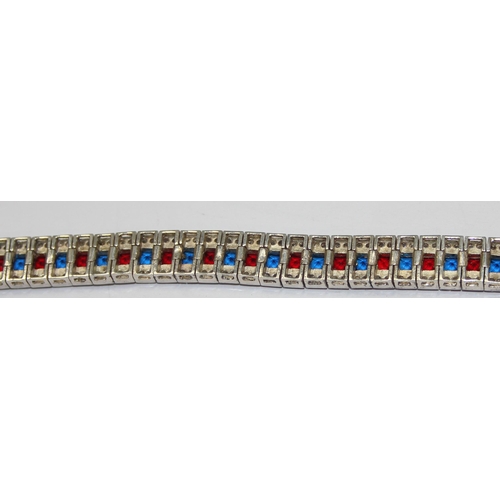 2273 - An Art Deco style 925 silver tennis bracelet, an alternating row of red and blue stones flanked on e... 