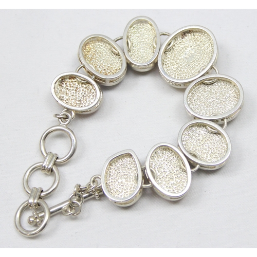 2280 - A silver and polished stone set bracelet, a silver and white stone set floral cuff bangle and a matc... 