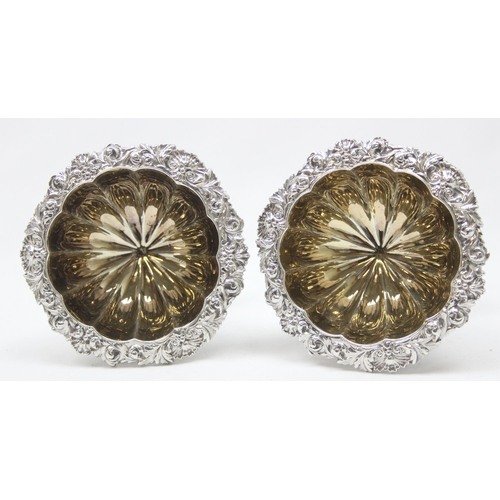 1001 - A pair of George IV period heavy gauge silver salts with gilt interior and floral border, armorial c... 