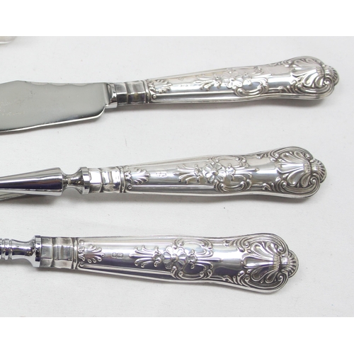 1015 - A pair of Victorian silver Apostle sugar tongs, London 1883, a silver tea spoon and a silver handled... 