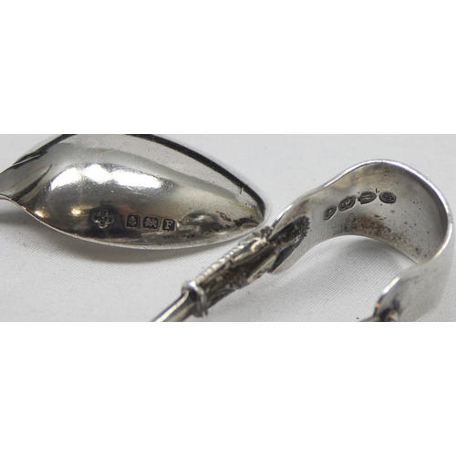 1015 - A pair of Victorian silver Apostle sugar tongs, London 1883, a silver tea spoon and a silver handled... 