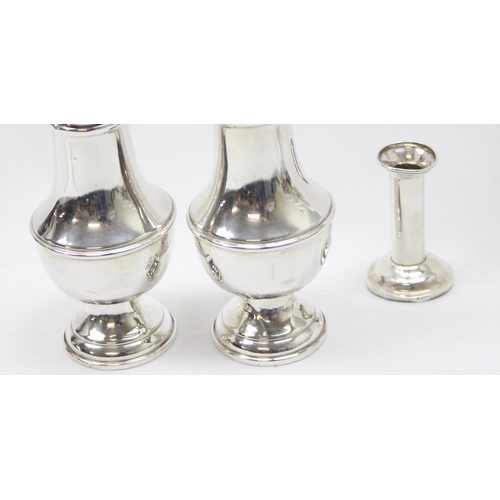 1038 - A pair of American weighted silver pepper pots and a weighted Sterling silver miniature candlestick ... 