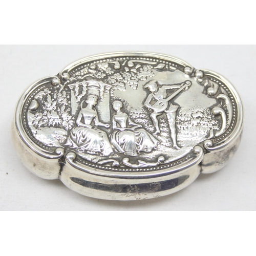 1058 - An antique silver snuff box the lid embossed with a Bucolic scene of a lute player and 2 ladies, Bir... 