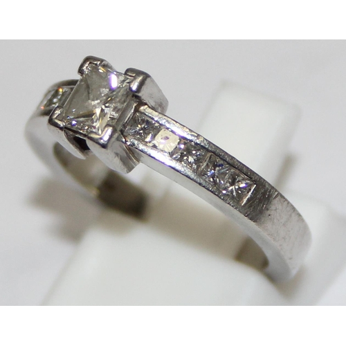 2293 - A Platinum ring set with a large central square Princess cut diamond and flanked with 5 similar squa... 