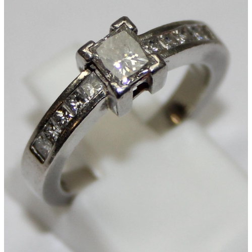 2293 - A Platinum ring set with a large central square Princess cut diamond and flanked with 5 similar squa... 