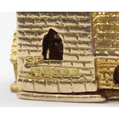 2319 - A vintage 9ct gold pendant or charm formed as a church opening to reveal a wedding scene, marked and... 