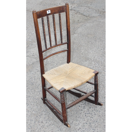 30 - In the manner of Liberty, an early 20th century child's bobbin turned rocking chair with rush seat, ... 