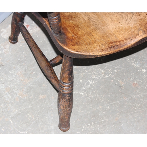 101 - An early 20th century elm seated farmhouse high back Windsor chair, approx 106cm tall