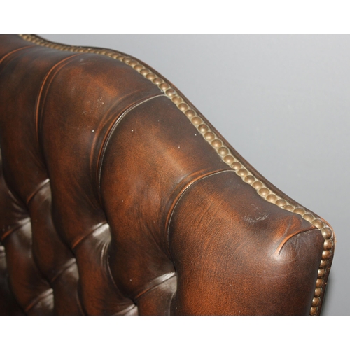 102 - A brown leather button backed and seated captain's or office swivel chair