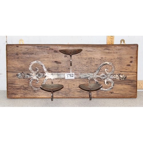 1762 - Hand forged rustic triple metal candle stand mounted on wooden wall mounting board, approx 55cm x  2... 