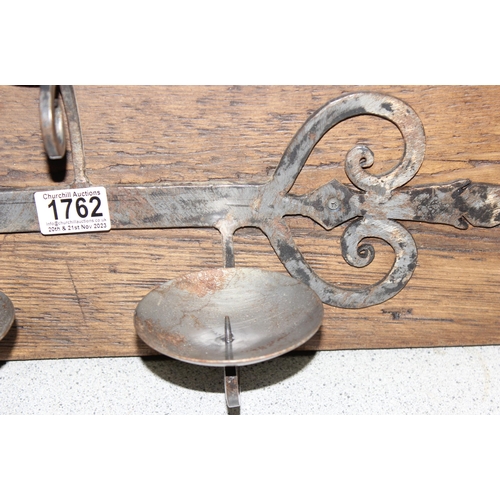 1762 - Hand forged rustic triple metal candle stand mounted on wooden wall mounting board, approx 55cm x  2... 