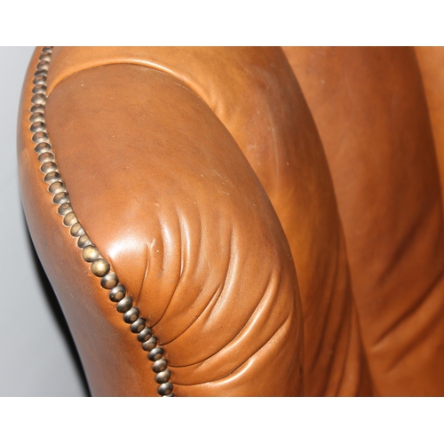 116 - A Georgian style light brown leather or leatherette club chair with ball and claw feet