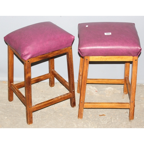 121 - 2 purple upholstered stools with wooden bases, approx 57cm tall