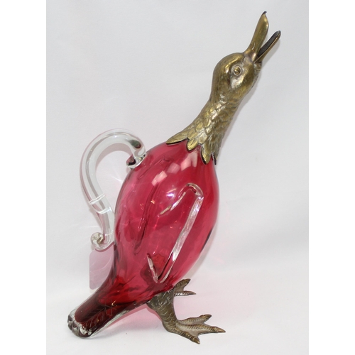 1655 - A rare cranberry glass and silver plate mounted decanter or claret jug formed as a duck, the feet ma... 