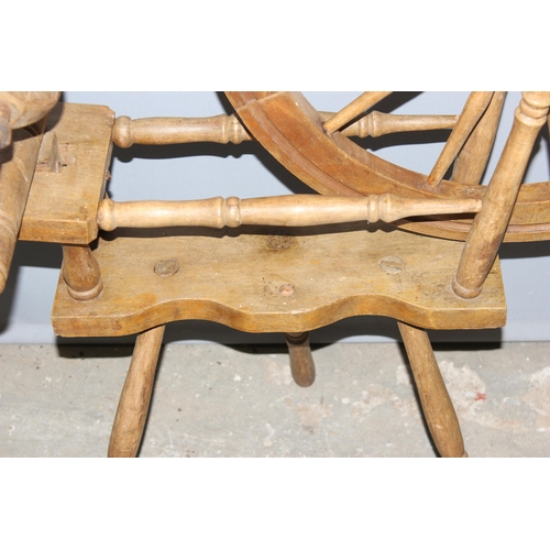 123 - A vintage wooden spinning wheel, approx 97cm wide