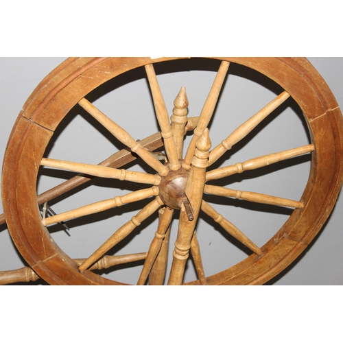 123 - A vintage wooden spinning wheel, approx 97cm wide