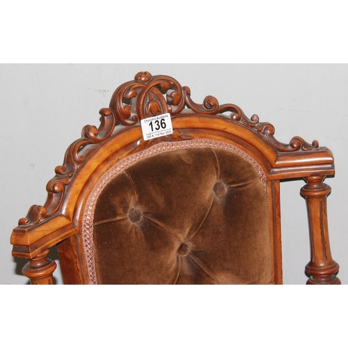 136 - A Victorian Mahogany nursing chair with carved frame, button back and ceramic castors