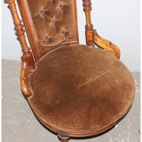 136 - A Victorian Mahogany nursing chair with carved frame, button back and ceramic castors