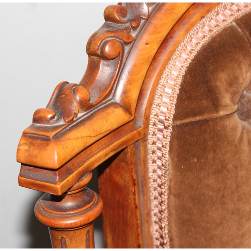 136 - A Victorian Mahogany nursing chair with carved frame, button back and ceramic castors