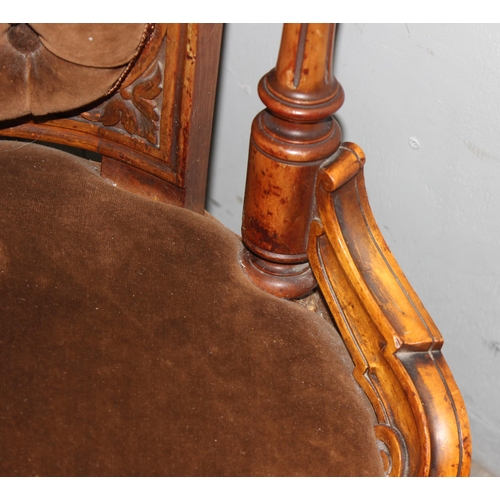 136 - A Victorian Mahogany nursing chair with carved frame, button back and ceramic castors