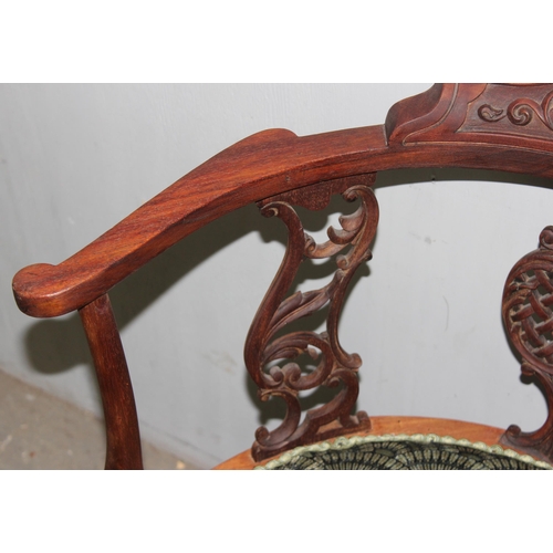 139 - A 19th century corner chair with carved frame and scalloped upholstery