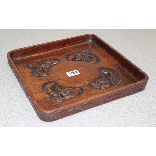 1802 - A vintage Oriental carved wooden tray depicting fish, approx 34cm square