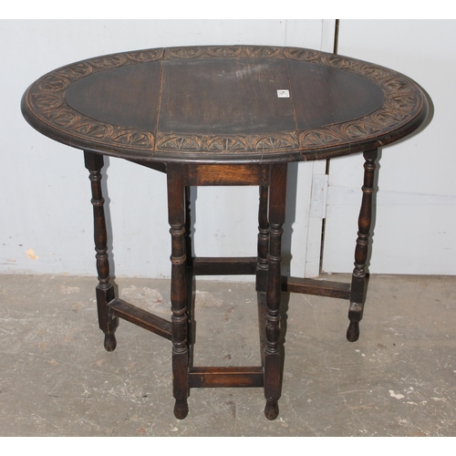 154 - A small vintage oak drop leaf table with carved border, approx 100cm wide x 60cm deep x 74cm tall