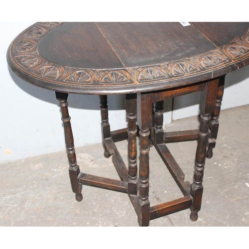 154 - A small vintage oak drop leaf table with carved border, approx 100cm wide x 60cm deep x 74cm tall