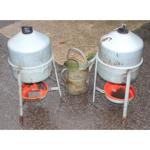 303 - 2 vintage chicken water feeders and a vintage galvanised watering can, the feeders approx 67cm tall