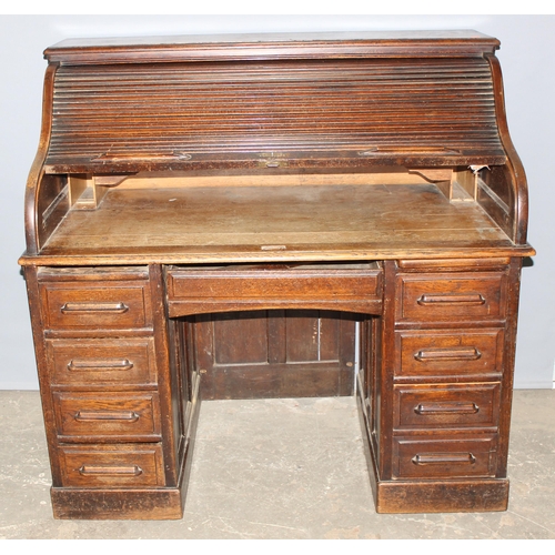 18 - An antique oak roll top desk with tambour front, approx 127cm wide x 76cm deep x 126cm tall