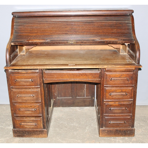 18 - An antique oak roll top desk with tambour front, approx 127cm wide x 76cm deep x 126cm tall