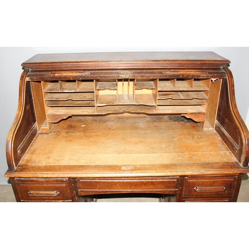 18 - An antique oak roll top desk with tambour front, approx 127cm wide x 76cm deep x 126cm tall