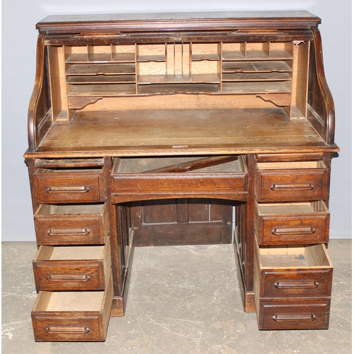 18 - An antique oak roll top desk with tambour front, approx 127cm wide x 76cm deep x 126cm tall