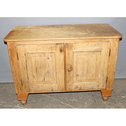 12 - An antique pine cupboard or sideboard, 2 doors opening to reveal a single shelf, standing on turned ... 