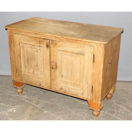 12 - An antique pine cupboard or sideboard, 2 doors opening to reveal a single shelf, standing on turned ... 