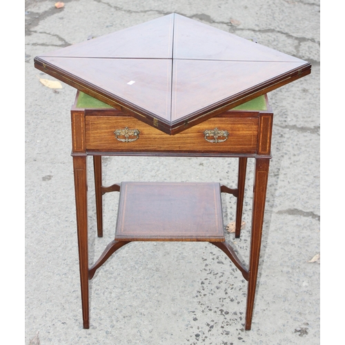 13 - A late 19th or early 20th century mahogany envelope card table with undertier, the top twists to ope... 