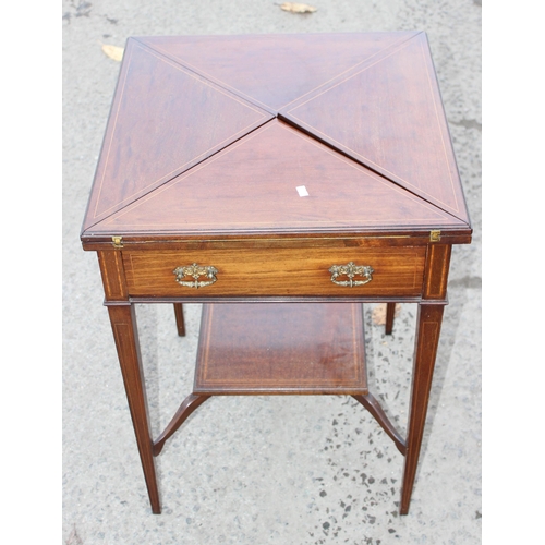 13 - A late 19th or early 20th century mahogany envelope card table with undertier, the top twists to ope... 