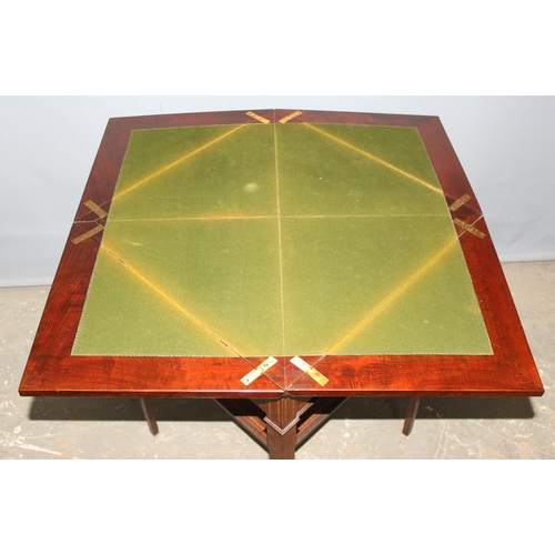 13 - A late 19th or early 20th century mahogany envelope card table with undertier, the top twists to ope... 