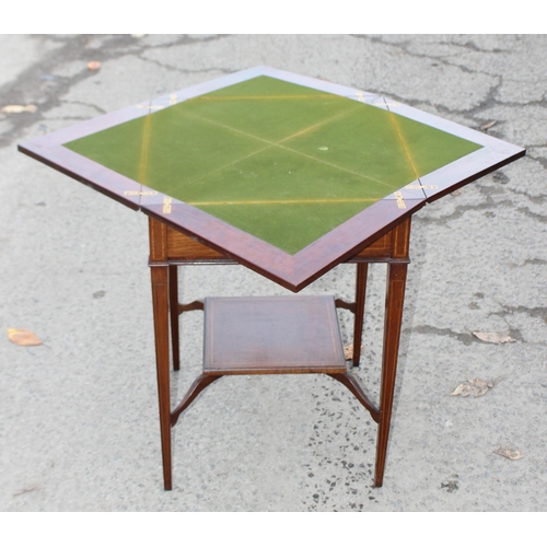 13 - A late 19th or early 20th century mahogany envelope card table with undertier, the top twists to ope... 